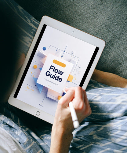 A person lying on a couch holds a tablet with a stylus, showing a digital flowchart titled 'Flow Guide' on the screen.